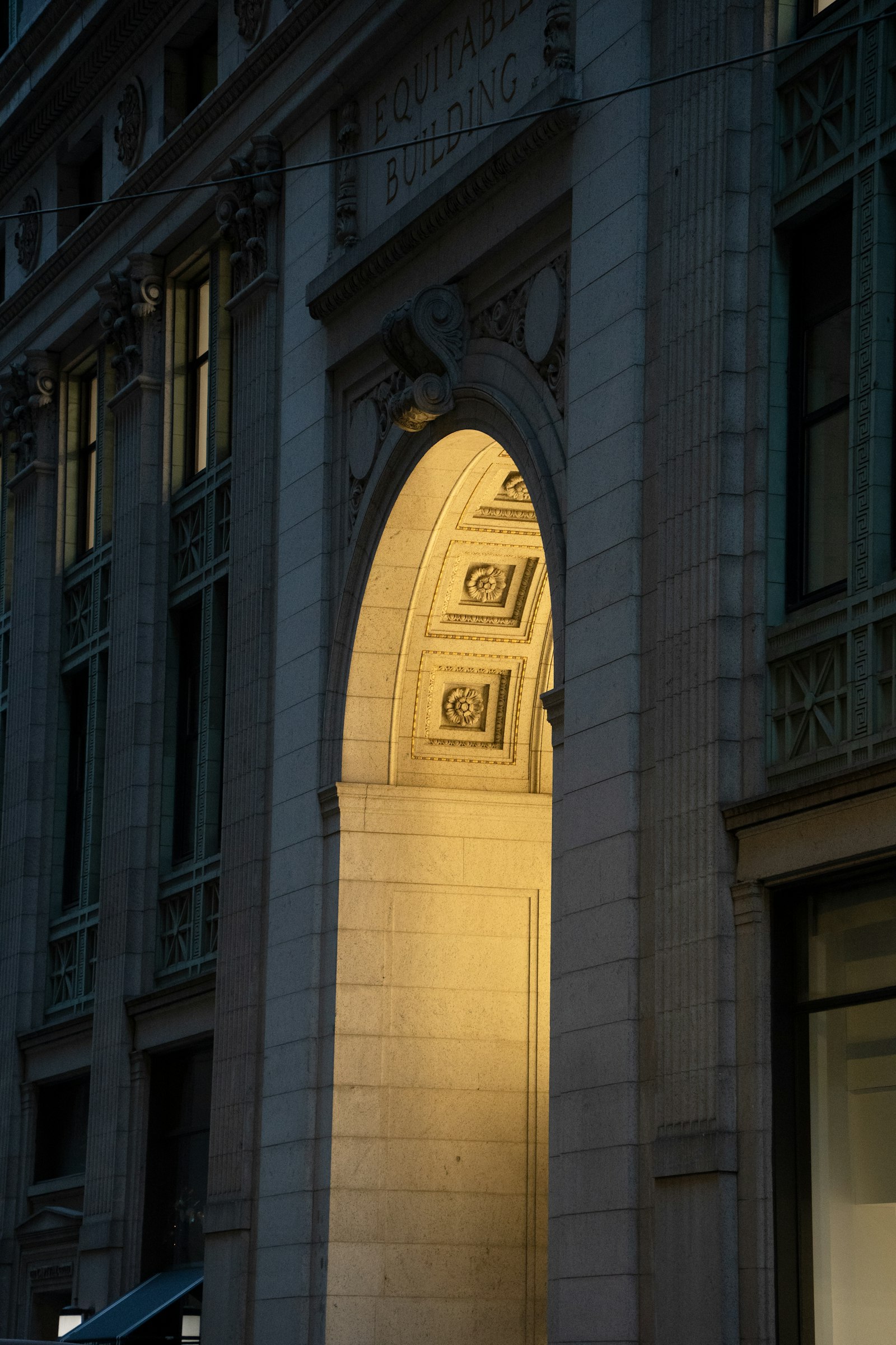 Arco iluminado na fachada clássica de um edifício ao anoitecer